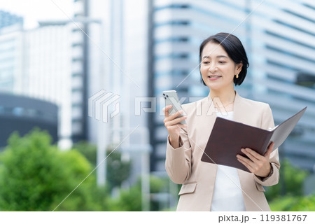 オフィス街で働くミドルのビジネスウーマン オフィス街で働くミドルのビジネスウーマン 119381767