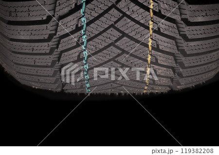 Car tire tread showcasing intricate pattern and colorful markings for enhanced grip and safety 119382208