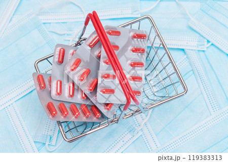 Pills and Capsules in Shopping Basket on the Surgical Masks Pills and Capsules in Shopping Basket on the Surgical Masks 119383313