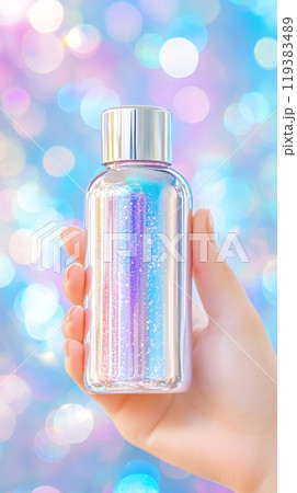 Glittering Metallic Bottle Held in Hand Against Dreamy Bokeh Background 119383489