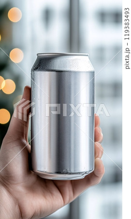Unlabeled Metallic Can in Hand Against a Bright, Festive Background 119383493