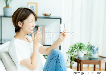 リビングでスマホを操作する女性 119383848