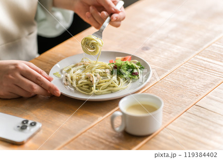 ランチでパスタを食べる女性の手元 119384402