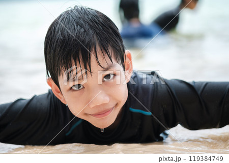 Close-up of Asian boy having fun on the beach looking at the camera 119384749