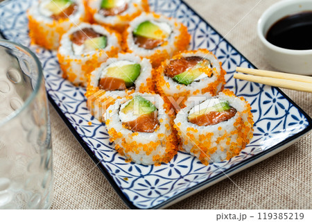 Plate is filled with California rolls with masago. Plate is filled with California rolls with masago. 119385219