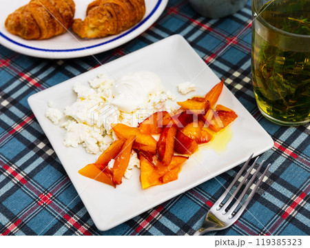 Caramelized peaches and light, tender cottage cheese with sour cream closeup 119385323