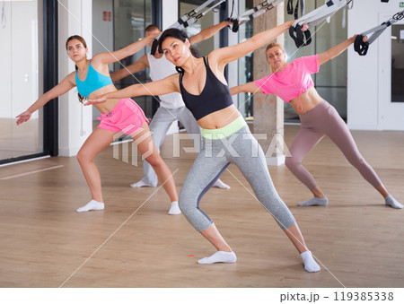 Four people doing pilates exercises with reformer Four people doing pilates exercises with reformer 119385338