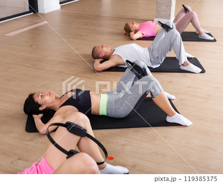 Group of adults exercising with pilates ring Group of adults exercising with pilates ring 119385375