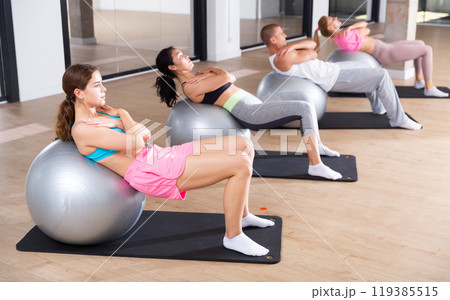 Group of people doing crunches on swiss balls Group of people doing crunches on swiss balls 119385515