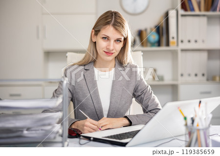 Office manager works with documents and laptop 119385659