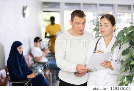 Young female doctor explaining prescribed treatment to worried man Young female doctor explaining prescribed treatment to worried man 119386106