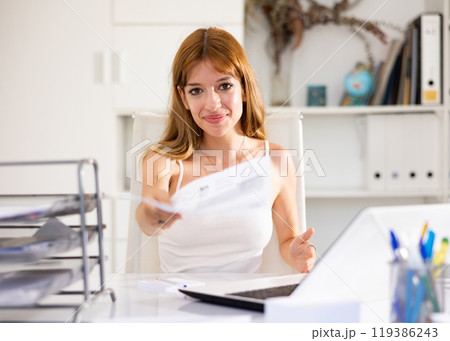 Woman hands over document for signing in office Woman hands over document for signing in office 119386243