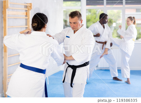 Adult man and young woman training karate techniques 119386335