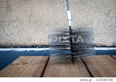 Close up of a metal steel wire brush for cleaning heaters and fireplaces. chimney sweepers Close up of a metal steel wire brush for cleaning heaters and fireplaces. chimney sweepers 119386796