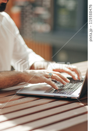 Freelancer Arabian man working with laptop in outdoors. Close up view on hands Freelancer Arabian man working with laptop in outdoors. Close up view on hands 119388476