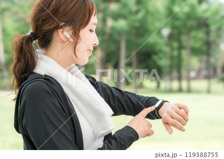 運動中にスマートウォッチを操作する女性（ヘルスケア・音楽・ワークアウト） 119388755