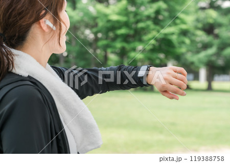 運動中にスマートウォッチを見る女性（ヘルスケア・音楽・ワークアウト） 119388758