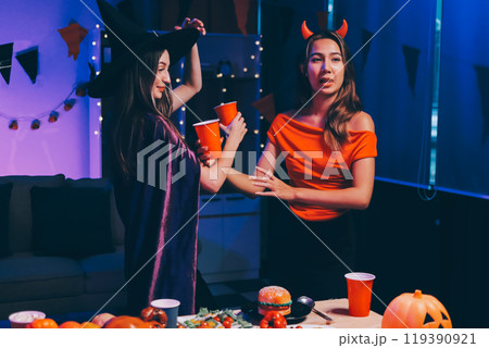 Joyful office Halloween party with coworkers in costumes, celebrating with drinks and laughter, fostering teamwork and festive spirit 119390921