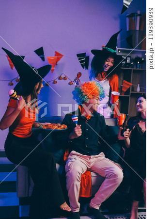 Joyful office Halloween party with coworkers in costumes, celebrating with drinks and laughter, fostering teamwork and festive spirit 119390939