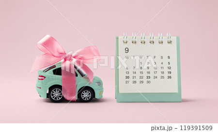 Car toy with bow and calendar on pink background 119391509
