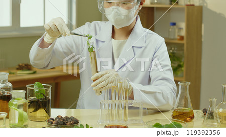 Shampoo study scene in laboratory by a female scientist, who sitting by yellow experiment table with many lab glassware  displayed on. Natural shampoo experiment template photo for advertisement 119392356