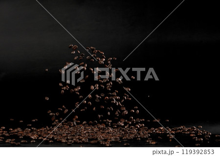 Coffee beans flying splashing in mid air. Black background isolated element. Many Coffee Beans flying explosion in air with aroma scent Coffee beans flying splashing in mid air. Black background isolated element. Many Coffee Beans flying explosion in air with aroma scent 119392853