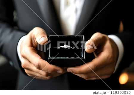 Elegant man in suit holding an engagement ring in a box 119393050