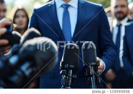 Politician giving speech surrounded by microphones and journalists 119393056
