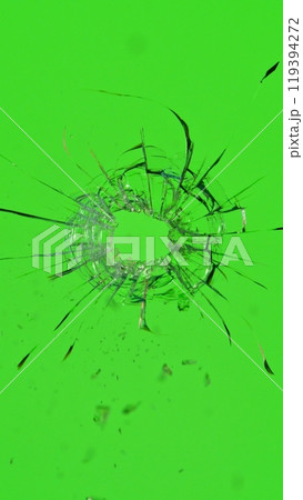 Close-up of gunshot through the glass, shattering against the green background 119394272