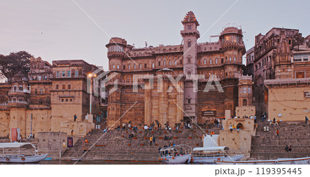 Varanasi, India. General View From Pleasure Boat On Sarvesvara And Digpatia Ghat. Purple Sunset Sky At Evening . Many Boats Moored On Ganga River. Camera Moving Along Riverbank Embankment Varanasi, India. General View From Pleasure Boat On Sarvesvara And Digpatia Ghat. Purple Sunset Sky At Evening . Many Boats Moored On Ganga River. Camera Moving Along Riverbank Embankment 119395445