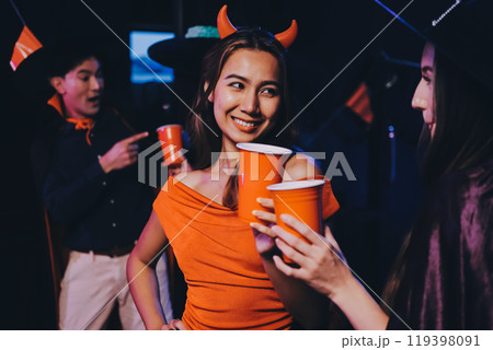 Joyful office Halloween party with coworkers in costumes, celebrating with drinks and laughter, fostering teamwork and festive spirit 119398091