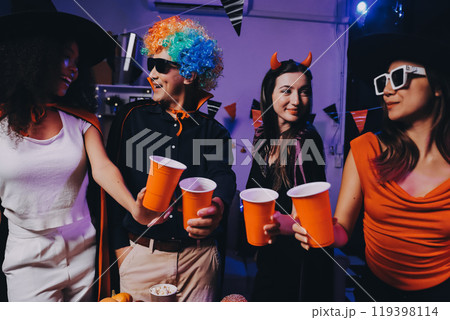 Joyful office Halloween party with coworkers in costumes, celebrating with drinks and laughter, fostering teamwork and festive spirit 119398114