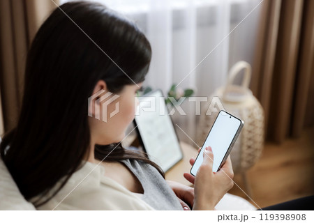 Pregnant woman with baby belly using mobile cell phone with white screen, search online shop, browse internet app. Closeup, copy space. Order food, chatting on device, booking a hotel, air ticket 119398908