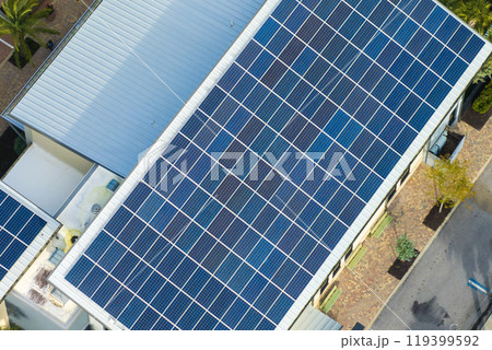 Florida office building with solar roof. Blue photovoltaic panels for producing clean ecological electric energy. Investing in renewable electricity concept Florida office building with solar roof. Blue photovoltaic panels for producing clean ecological electric energy. Investing in renewable electricity concept 119399592