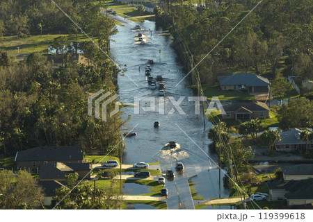 Hurricahe fainfall flooded Florida road with evacuating cars and surrounded with water houses in suburban residential area Hurricahe fainfall flooded Florida road with evacuating cars and surrounded with water houses in suburban residential area 119399618