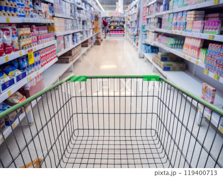 Trolley in department store Abstract blurred of colorful shelves, Shopping cart in supermarket. Empty red shopping cart view with warm light. 119400713