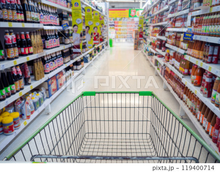Shopping cart in supermarket, Trolley in department store Abstract blurred of colorful shelves, Empty red shopping cart view with warm light. 119400714