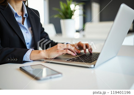 Focused businesswoman working on laptop in sleek, modern office setting with smartphone beside. Engaged in professional task, showcasing dedication and focus Focused businesswoman working on laptop in sleek, modern office setting with smartphone beside. Engaged in professional task, showcasing dedication and focus 119401196