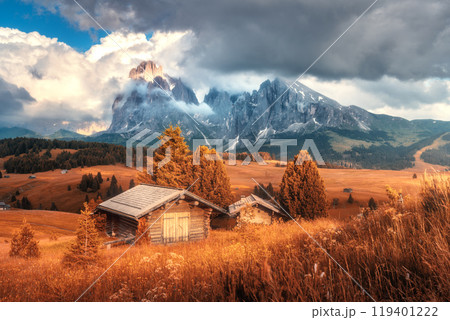 Wooden houses on orange meadows in mountain valley in autumn 119401222