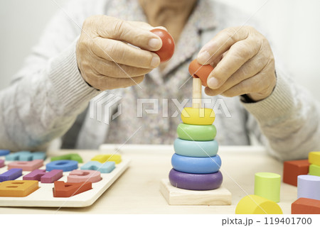 Asian elderly woman playing game. 119401700