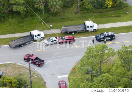 Car crash site with emergency services personnel and vehicles responding to accident on American street. First responders helping victims of vehicle collision on bridge road in USA Car crash site with emergency services personnel and vehicles responding to accident on American street. First responders helping victims of vehicle collision on bridge road in USA 119401970