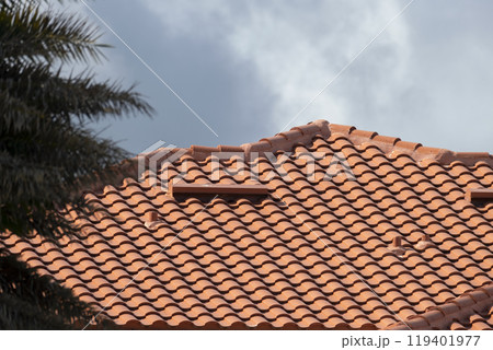 Closeup of house rooftop covered with ceramic shingles. Tiled covering of building 119401977