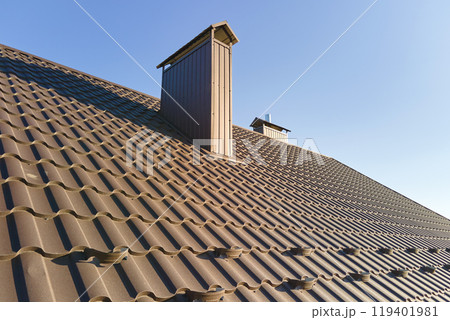 Closeup snow guard for safety in winter on house roof top covered with steel shingles. Tiled covering of building Closeup snow guard for safety in winter on house roof top covered with steel shingles. Tiled covering of building 119401981