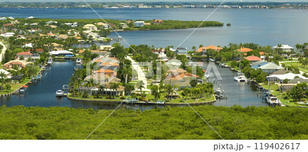 Aerial view of rural private houses in remote suburbs located near Florida wildlife wetlands with green vegetation on sea bay shore. Living close to nature concept 119402617