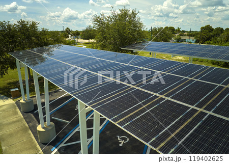Aerial view of solar panels installed as shade roof over parking lot for parked cars for effective generation of clean electricity. Photovoltaic technology integrated in urban infrastructure 119402625