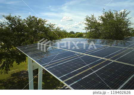 Aerial view of solar panels installed as shade roof over parking lot for parked cars for effective generation of clean electricity. Photovoltaic technology integrated in urban infrastructure Aerial view of solar panels installed as shade roof over parking lot for parked cars for effective generation of clean electricity. Photovoltaic technology integrated in urban infrastructure 119402626