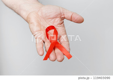Man holding red AIDS awareness ribbon. World AIDS Day 119403090
