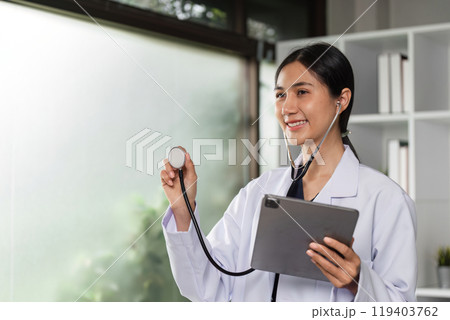 Confident Female Doctor in Modern Clinic Holding Stethoscope and Tablet for Patient Consultation and Healthcare Services 119403762