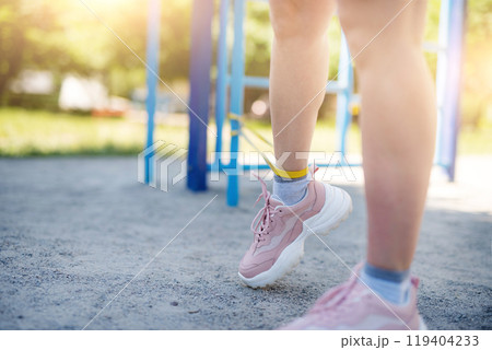 Woman training legs with elastic band 119404233