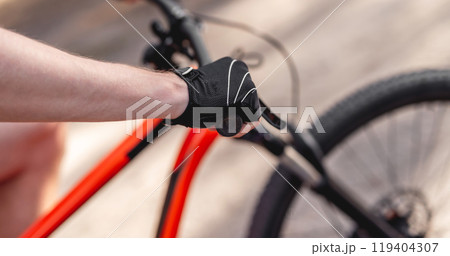 Hand in sport glove on handlebar Hand in sport glove on handlebar 119404307